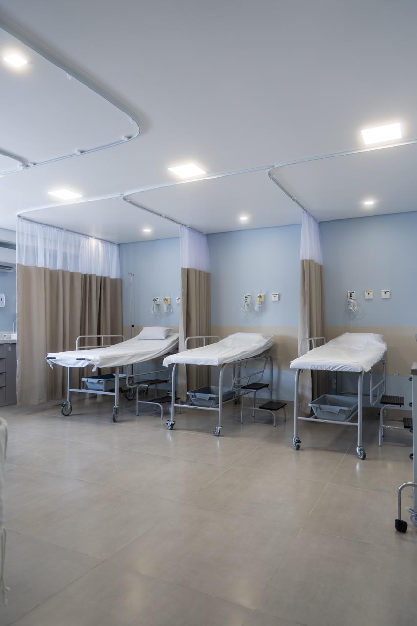 Sala de recuperação pós-procedimento com leitos e cortinas divisórias