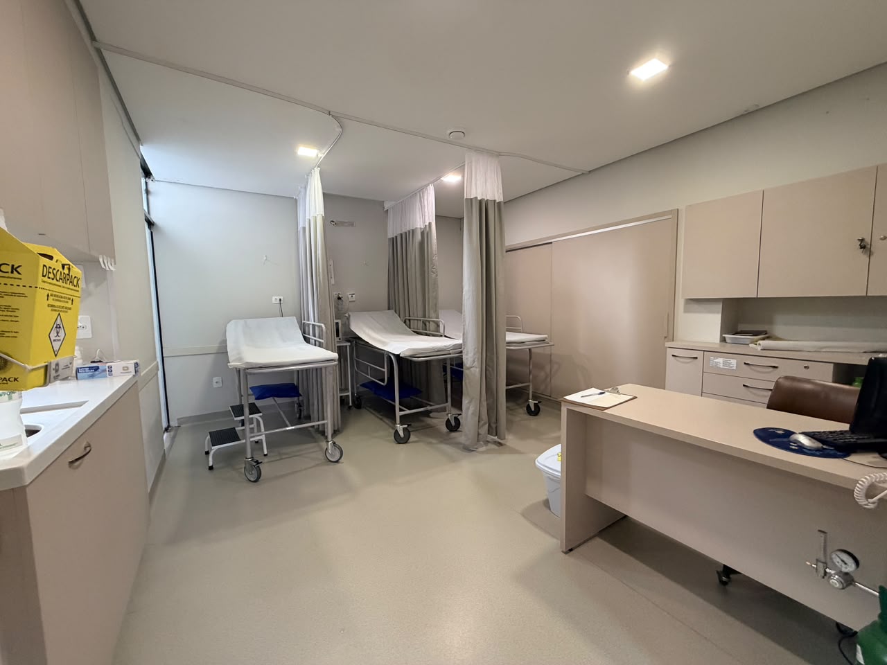 Consultório médico da Geron Gastro com mesa de atendimento e maca de exame